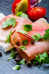 Curled Slices of Delicious Prosciutto with parsley leaves 