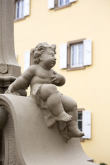 stone cherub in front of an old house