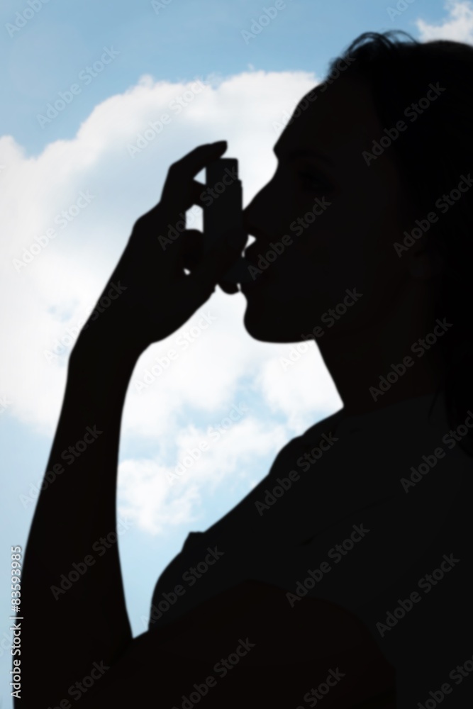 Poster Composite image of asthmatic brunette using her inhaler 