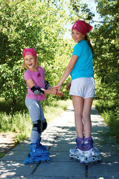 Two girls in roller skates looking at the camera.