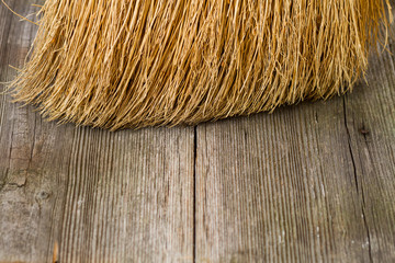 closeup of broom on wooden background