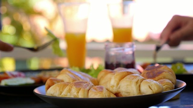 Couple Having Breakfast with Croissants, Jam, Fried Egg and