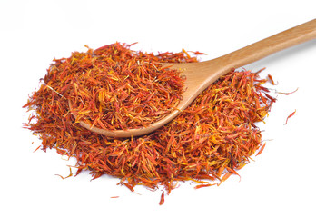 Fototapeta premium Safflower petals in a spoon on white background