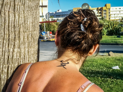 Femme avec un tatouage dans le cou