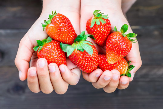 Strawberries close up.Kids hands holding strawberries.
