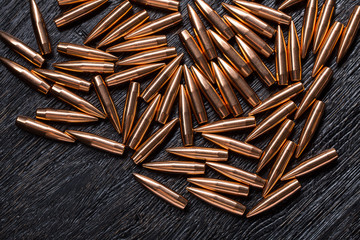 Placer copper bullets on a dark wooden background