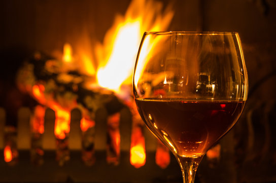 Glas Rotwein am Kamin