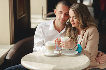 Happy couple drinking coffee in a local cafe.