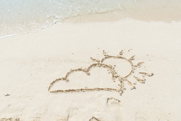 Sunny with some cloud weathe written in sand