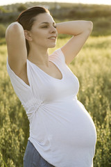 Fototapeta na wymiar Pregnant woman with back sunset light