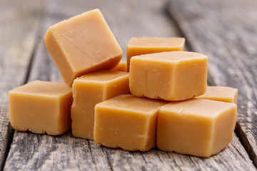 Tasty toffees on wooden background.