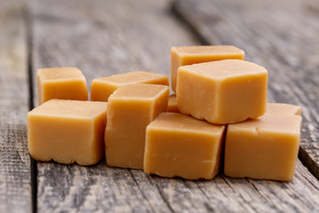 Tasty toffees on wooden background.
