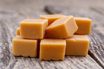 Tasty toffees on wooden background.
