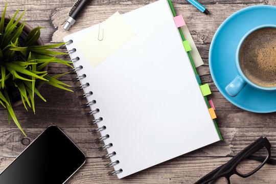 Office desk open spiral paper notebook business background