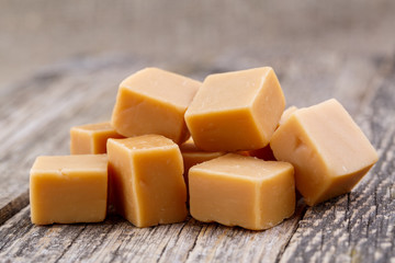 Tasty toffees on wooden background.