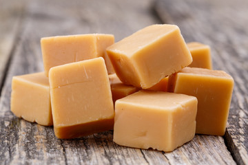Tasty toffees on wooden background.