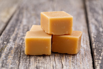 Tasty toffees on wooden background.