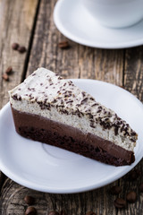 Chocolate dessert with coffee cup and coffee beans on wooden bac
