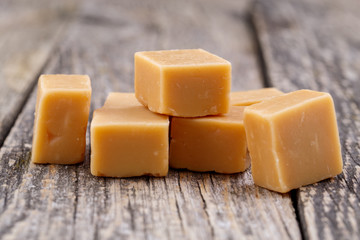 Tasty toffees on wooden background.