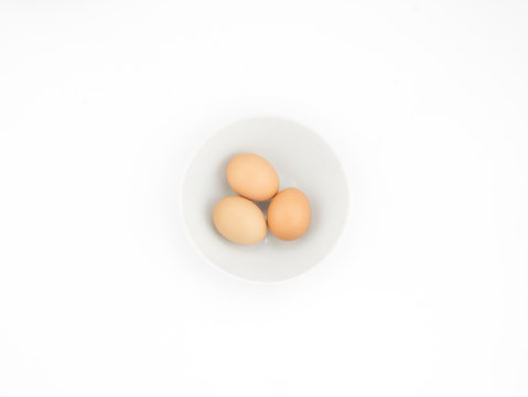 Eggs in white bowl isolated on white background