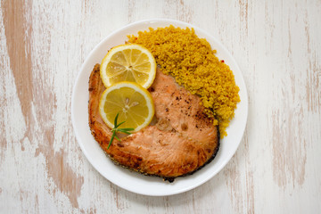 fried salmon with couscous on plate