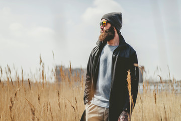 Bearded man standing in a dry field - Powered by Adobe