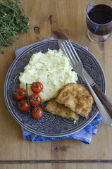 Chicken kievs with mashed potatoes and grilled cherry tomatoes