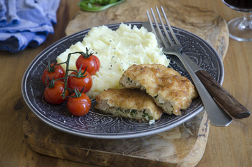 Chicken kievs with mashed potatoes and grilled cherry tomatoes