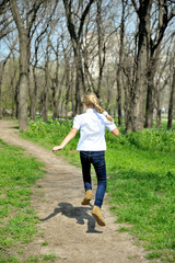 Young happy girl running at green park