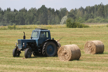 Fototapeta na wymiar Traktor bei der Heuernte II