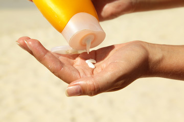 women squeezing suncream