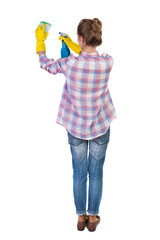 Back view of a housewife in gloves with sponge and detergent.