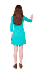 back view of woman. Young woman presses down on something.