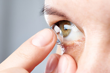 Woman puts contact lens