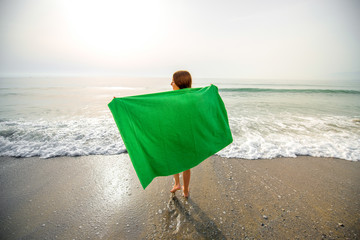 Woman in green towel on the beach