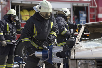 firefighters with the pneumatic shears open the car doors