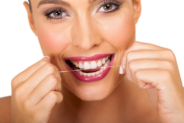 young woman using dental floss