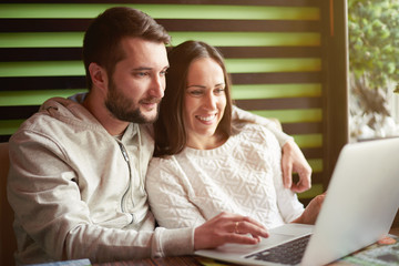 couple using laptop in restaurant