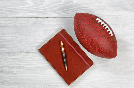 Playbook with Football on rustic white wood