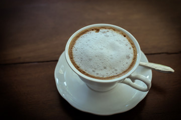 hot milk  Latte coffee on wooden table - vintage tone