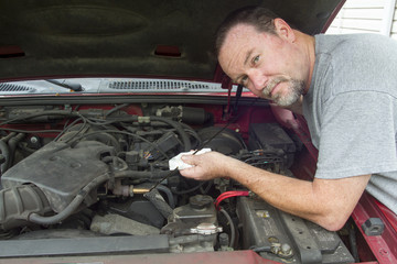 Mechanic Checking Oil Levels On A Older Vehicle
