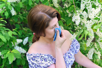 woman with allergic rhinitis about bird cherry blossoms