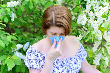 woman with allergic rhinitis about bird cherry blossoms
