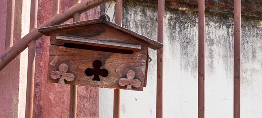 Wooden mailbox hanging on the gate