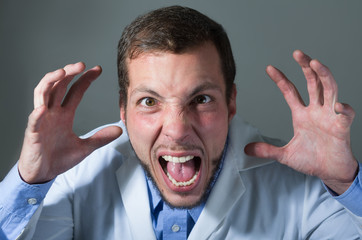 Closeup portrait of handsome young doctor screaming