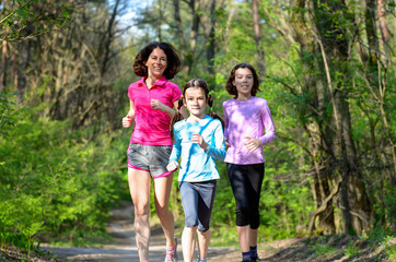Family sport, mother and kids jogging, running in forest
