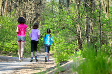 Family sport, mother and kids jogging, running in forest
