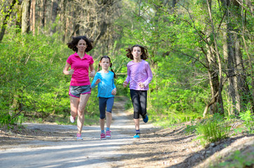 Family sport, mother and kids jogging, running in forest
