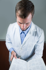 Closeup portrait of handsome young doctor reading