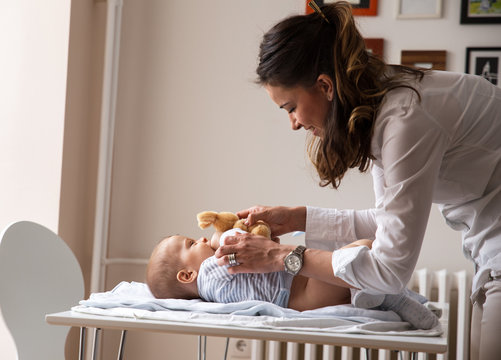 Mother Changing Her Baby Diapers.